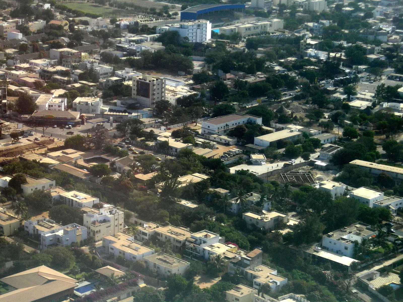 Un quartier résidentiel de Dakar vu du ciel : maisons, immeubles bas et arbres